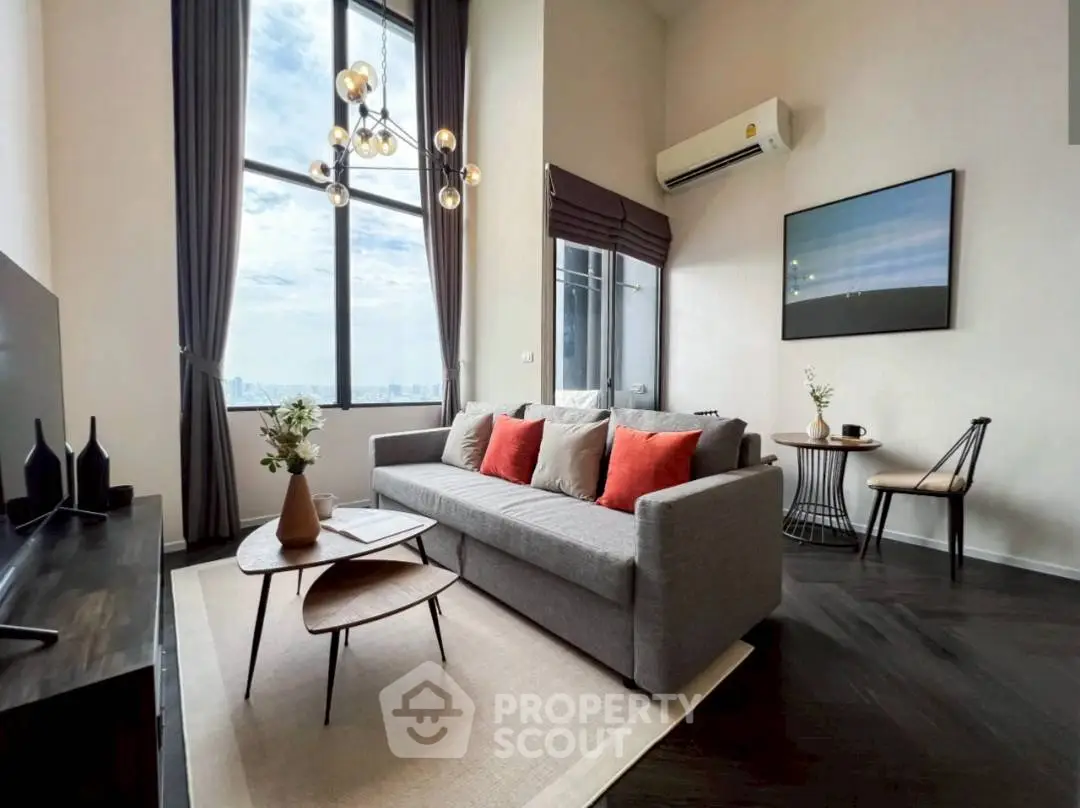 Stylish modern living room with high ceilings and city view, featuring elegant decor and natural light.