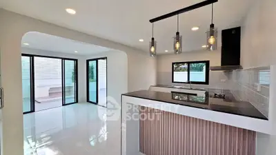 Modern open-layout kitchen with sleek design and ample natural light