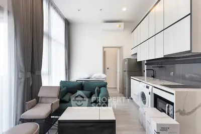 Modern living room with open kitchen, featuring sleek appliances and stylish furniture.