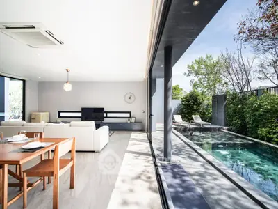 Luxurious open-plan living room with pool view and modern furnishings