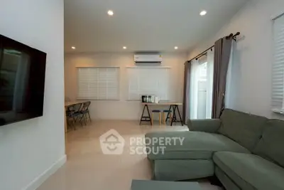 Spacious living room with modern decor and natural light, featuring a cozy sectional sofa and dining area.