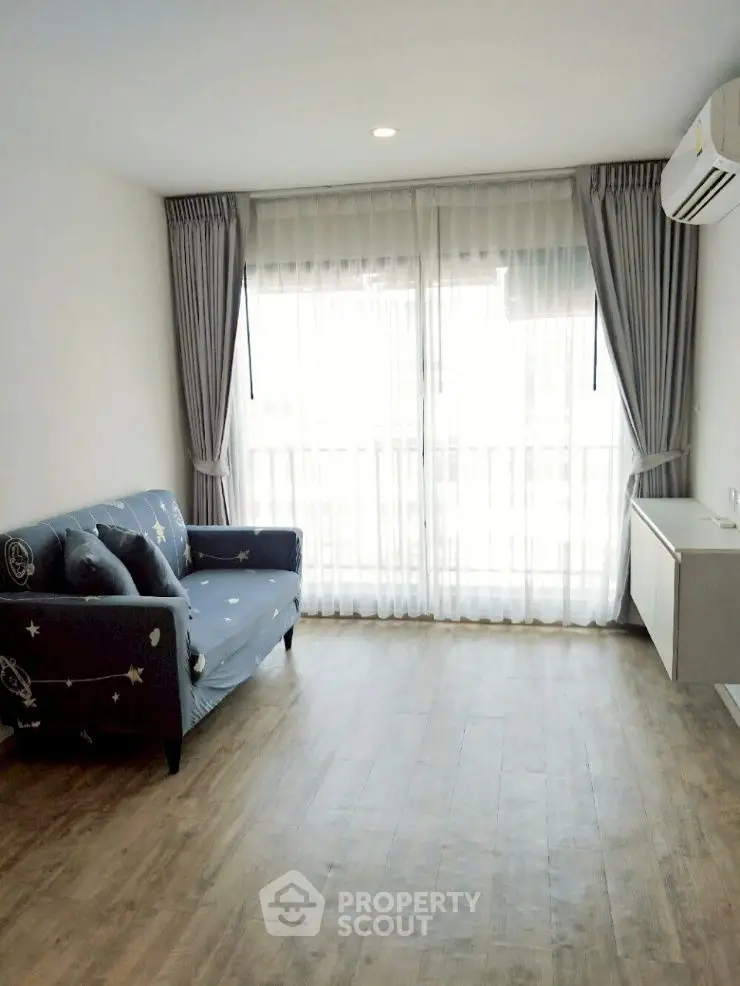 Bright living room with wooden flooring and cozy sofa in modern apartment.