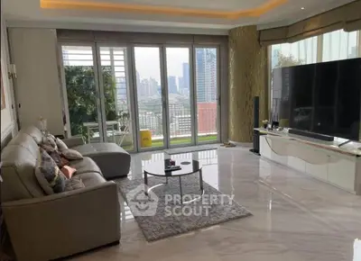 Luxurious living room with city view, large windows, and modern furnishings in a high-rise apartment.