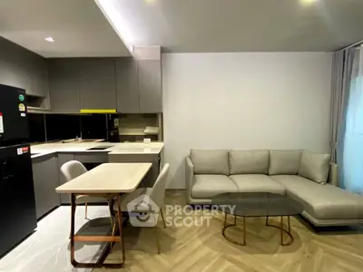 Modern open-plan kitchen and living room with sleek furniture and neutral tones.