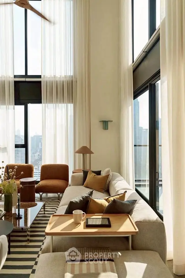 Luxurious high-ceiling living room with modern decor and panoramic city views.