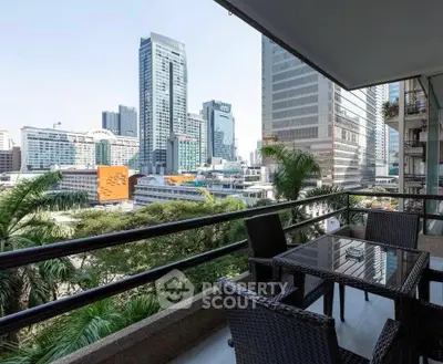 Spacious balcony with city skyline view and outdoor seating area.