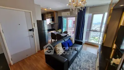 Modern living room with city view, elegant chandelier, and cozy seating area in a high-rise apartment.