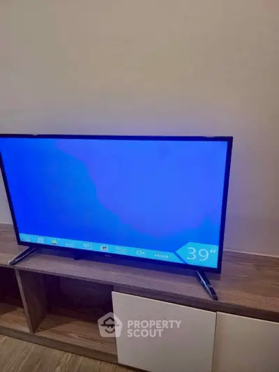 Modern living room with sleek TV on stylish wooden cabinet, perfect for entertainment.