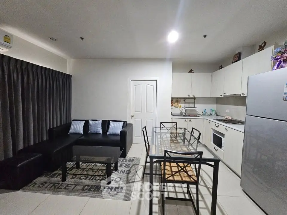 Modern open-layout kitchen and living room with sleek furniture and appliances.
