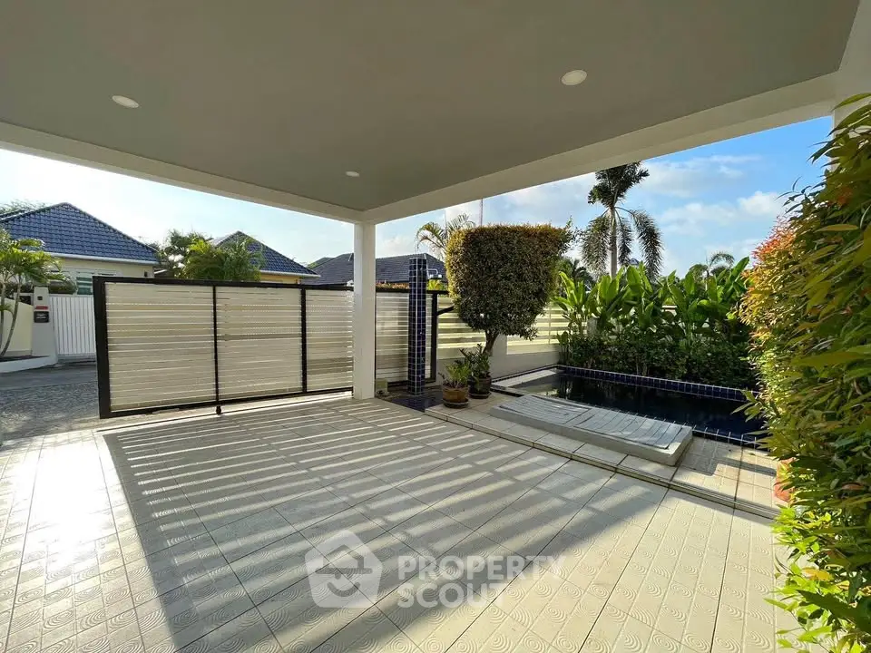 Spacious covered patio with pool and lush garden view in modern home