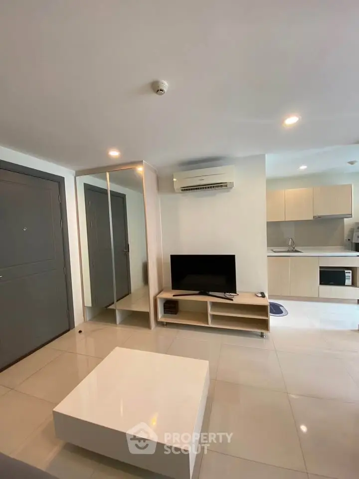 Modern living room with sleek furniture and open kitchen layout in a stylish apartment.