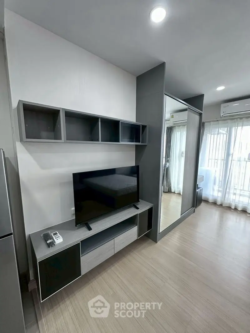 Modern living room with sleek TV unit and large window for natural light