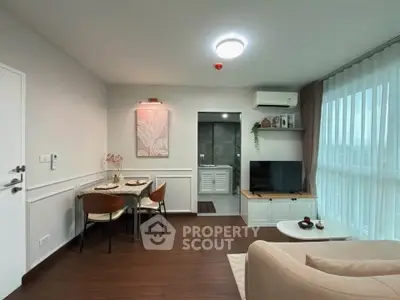 Modern living room with dining area, TV, and large window with natural light.