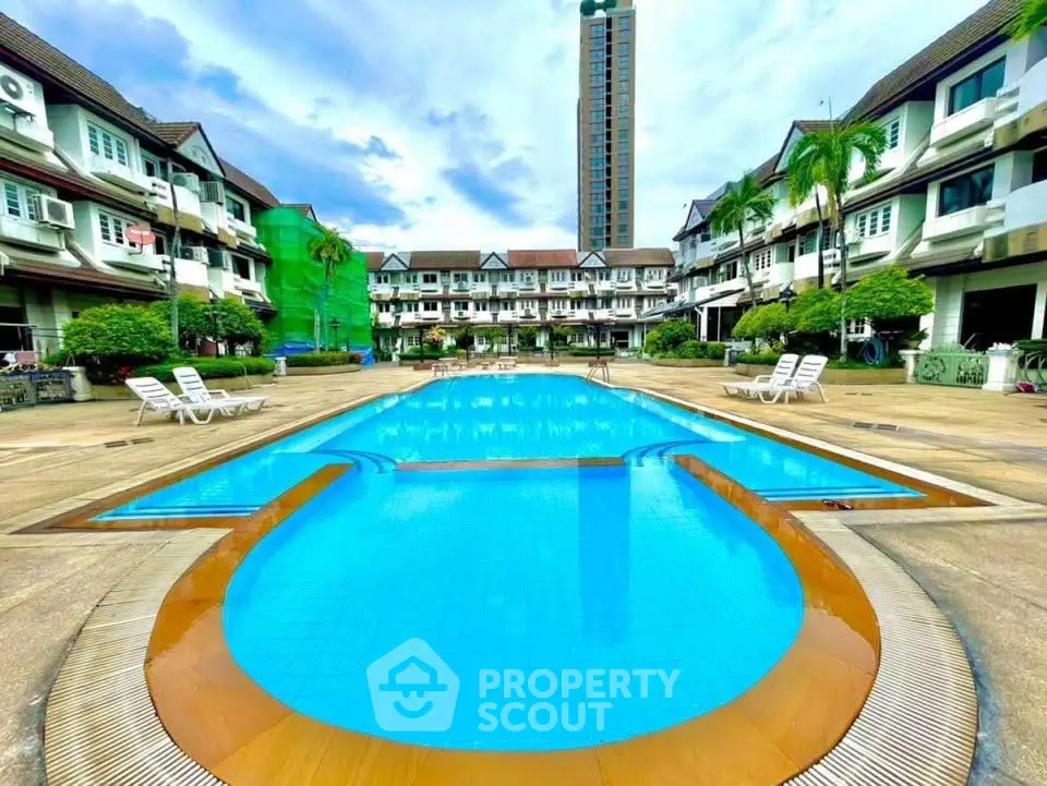 Luxurious residential complex with inviting pool and lush surroundings