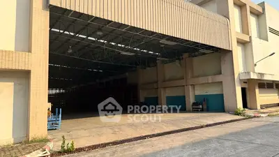 Spacious industrial warehouse with open entrance and ample storage space.