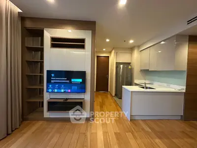 Modern open-layout living room with sleek kitchen and wooden flooring