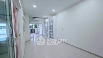 Spacious modern living room with built-in shelves and sliding glass doors to balcony.