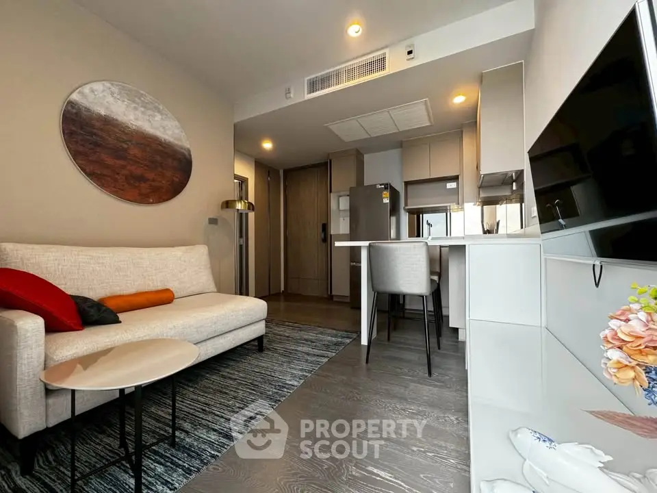 Modern living room with open kitchen, stylish decor, and cozy seating area in a contemporary apartment.