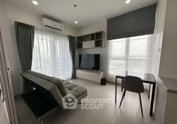 Modern living room with sleek furniture and large windows offering natural light.