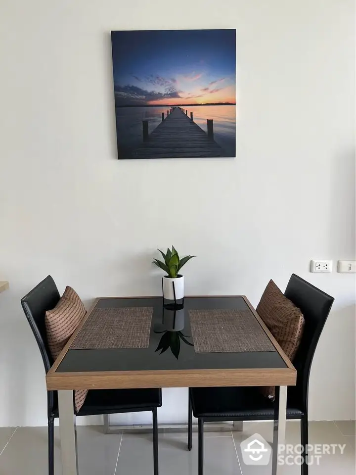 Modern dining area with sleek table and chairs, featuring elegant wall art and cozy ambiance.