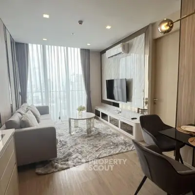 Modern living room with stylish decor and large windows offering natural light.