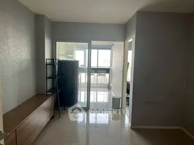 Spacious modern living room with glass doors leading to a bright balcony area.