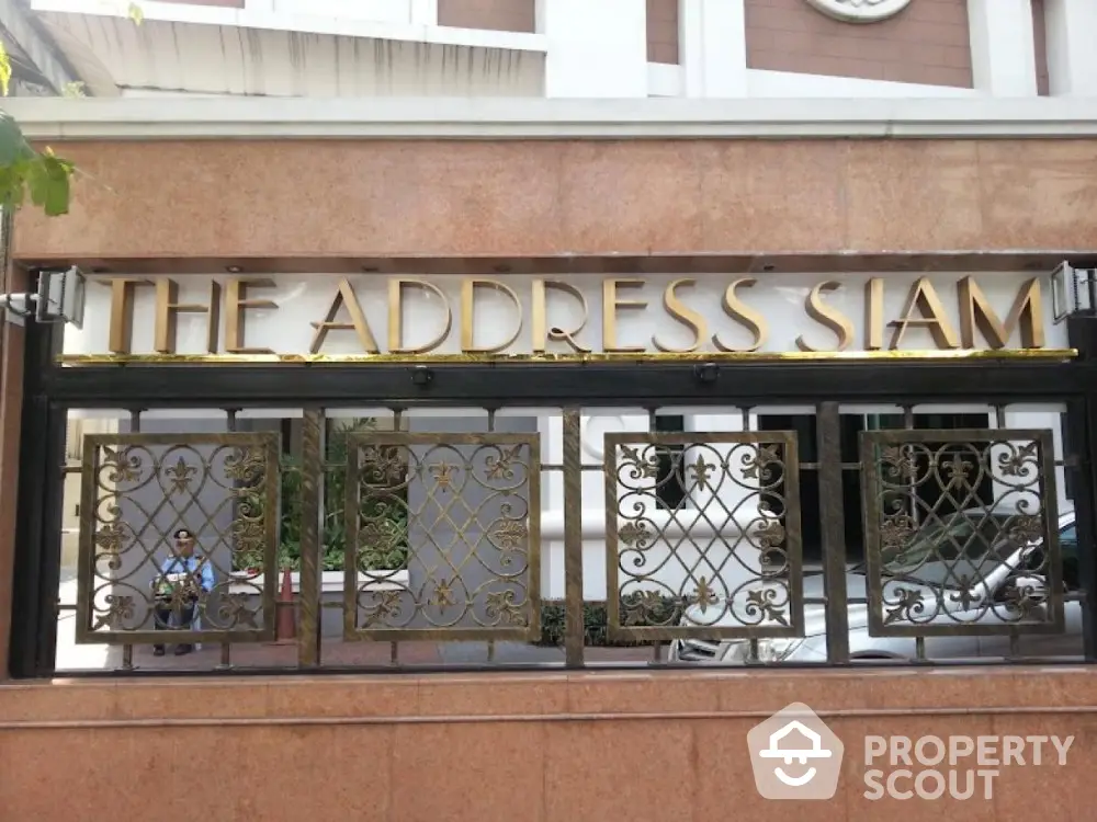 Elegant entrance sign of The Address Siam with ornate metalwork and luxurious design.