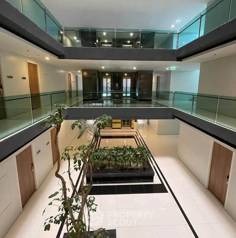 Modern apartment building interior with open corridors and indoor plants
