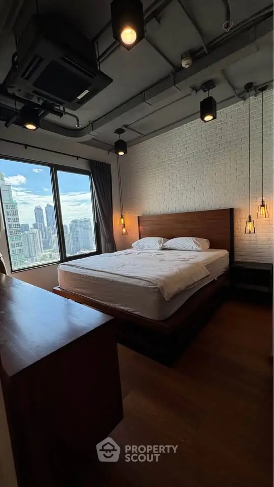 Modern bedroom with city view, featuring stylish lighting and wooden flooring.