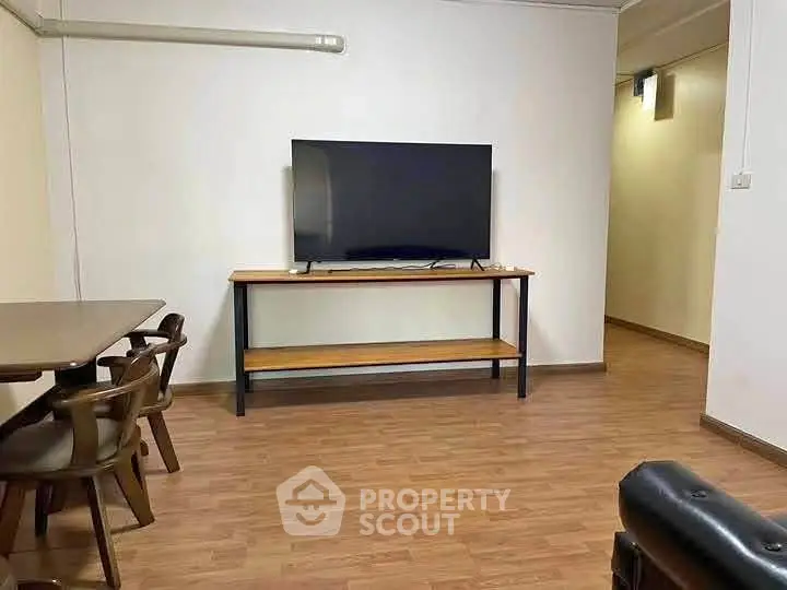 Spacious living room with modern TV and wooden flooring