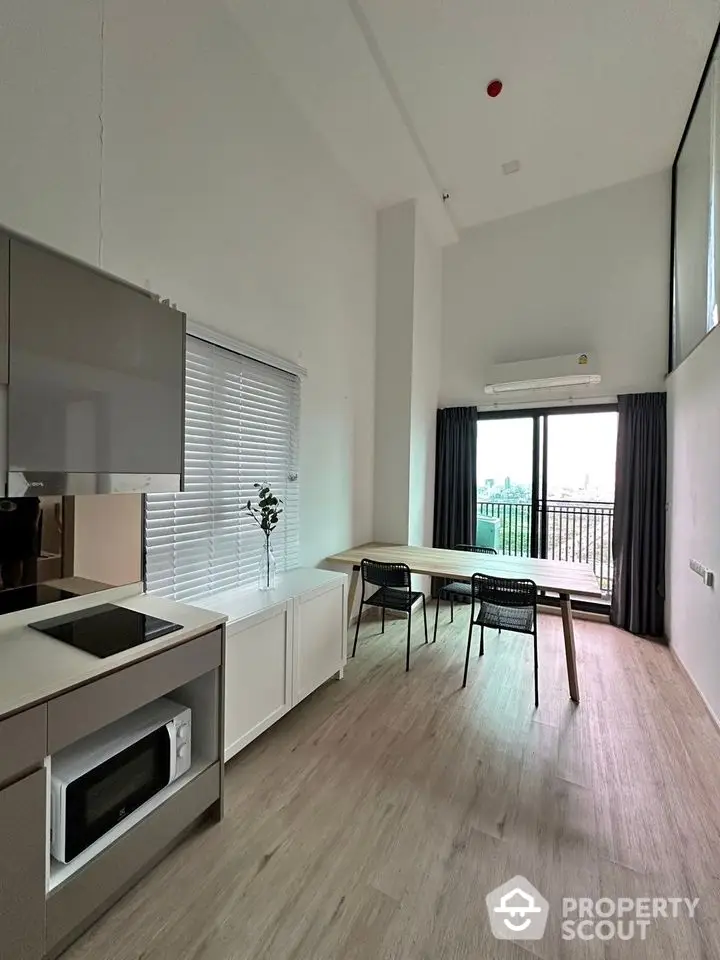 Modern open-plan living area with high ceilings and balcony view