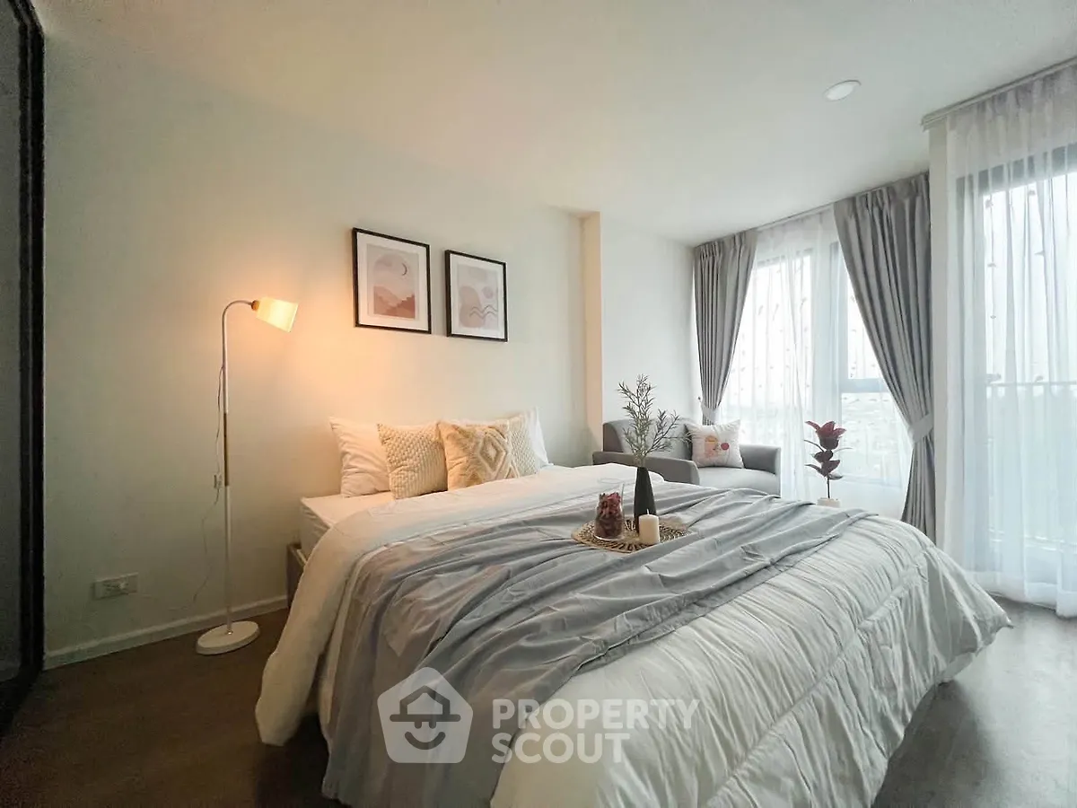 Elegant bedroom with cozy decor and large windows offering natural light
