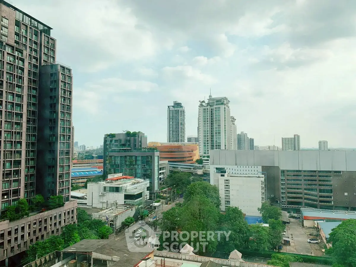 Stunning cityscape view from a high-rise building showcasing urban architecture and greenery.