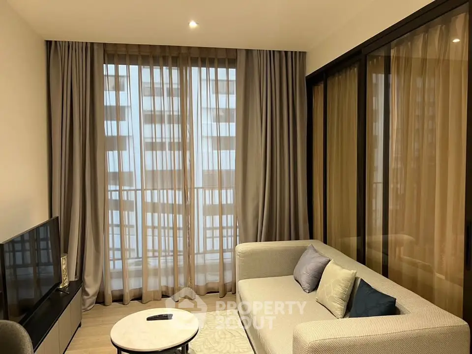 Modern living room with large windows and stylish furniture in a high-rise apartment.