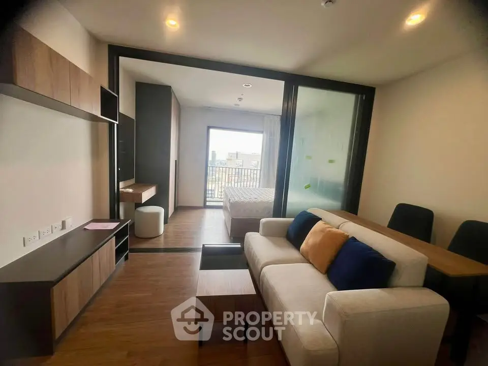 Modern open-plan living room with stylish furniture and balcony view