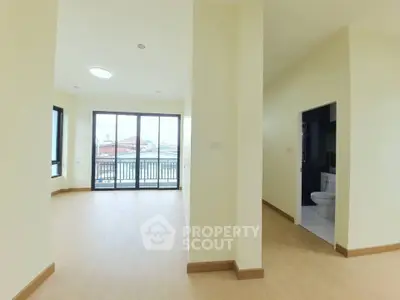 Spacious apartment with bright living area and balcony access, featuring modern flooring and ample natural light.