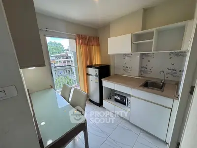 Modern kitchen with sleek cabinetry and balcony view, perfect for urban living.