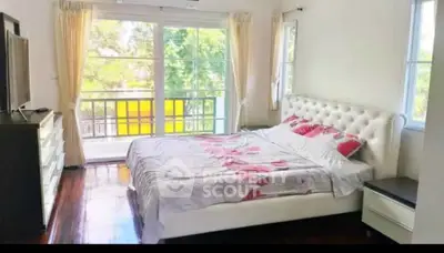 Spacious bedroom with elegant decor and balcony access in a modern home.