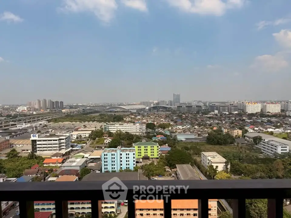 Stunning cityscape view from a high-rise balcony showcasing urban skyline and blue skies.