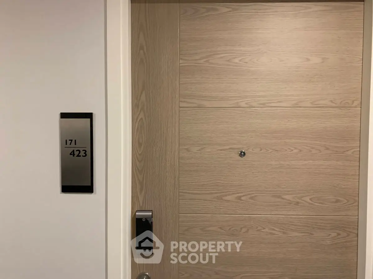 Modern apartment entrance with sleek wooden door and digital lock