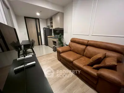 Modern living room with leather sofa and sleek kitchen area