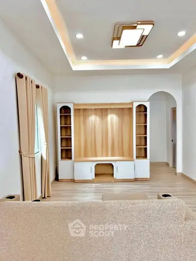Modern living room with elegant ceiling lights and built-in wooden shelves