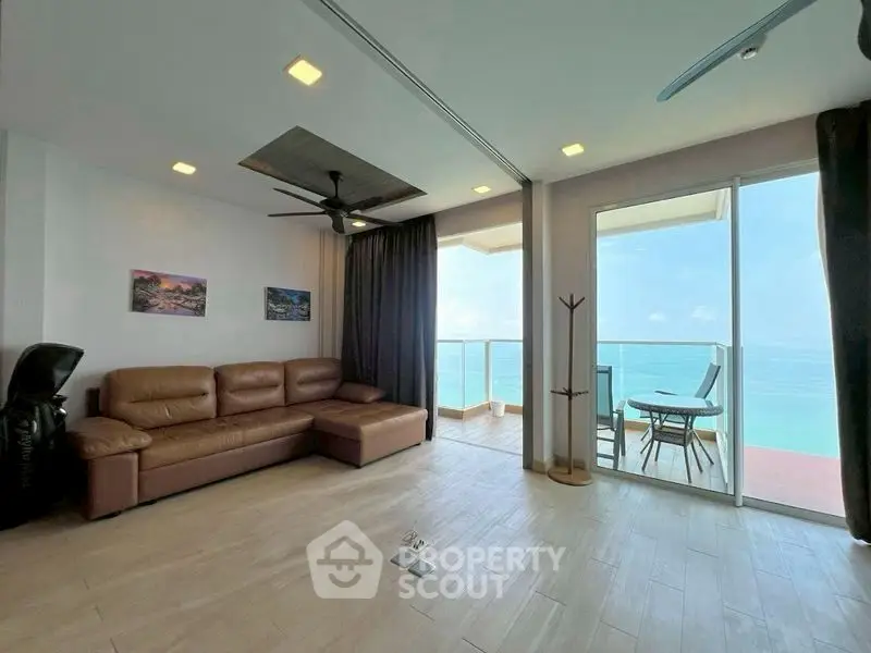 Spacious living room with ocean view and modern balcony access.