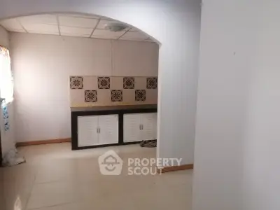 Spacious kitchen with tiled backsplash and ample natural light.