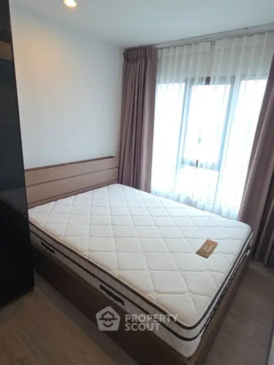 Cozy bedroom with large window and elegant curtains, featuring a comfortable bed and modern design.