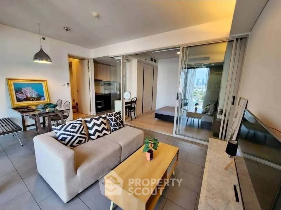 Modern open-plan living room with stylish decor and city view, featuring a cozy sofa and dining area.