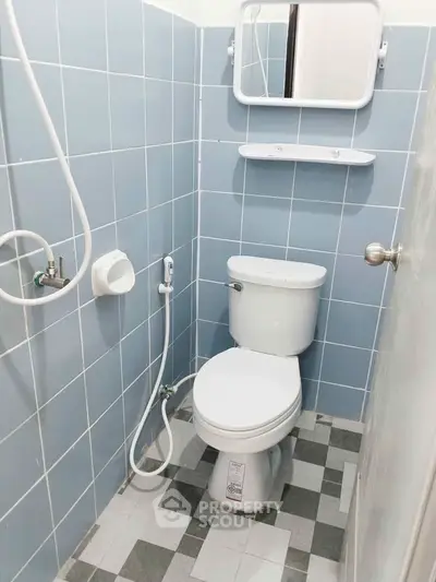 Compact bathroom with blue tiles and modern fixtures, ideal for small spaces.