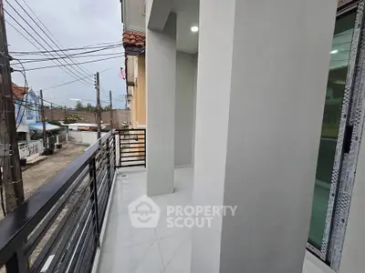Modern balcony with sleek railing and tiled flooring offering a serene outdoor space.