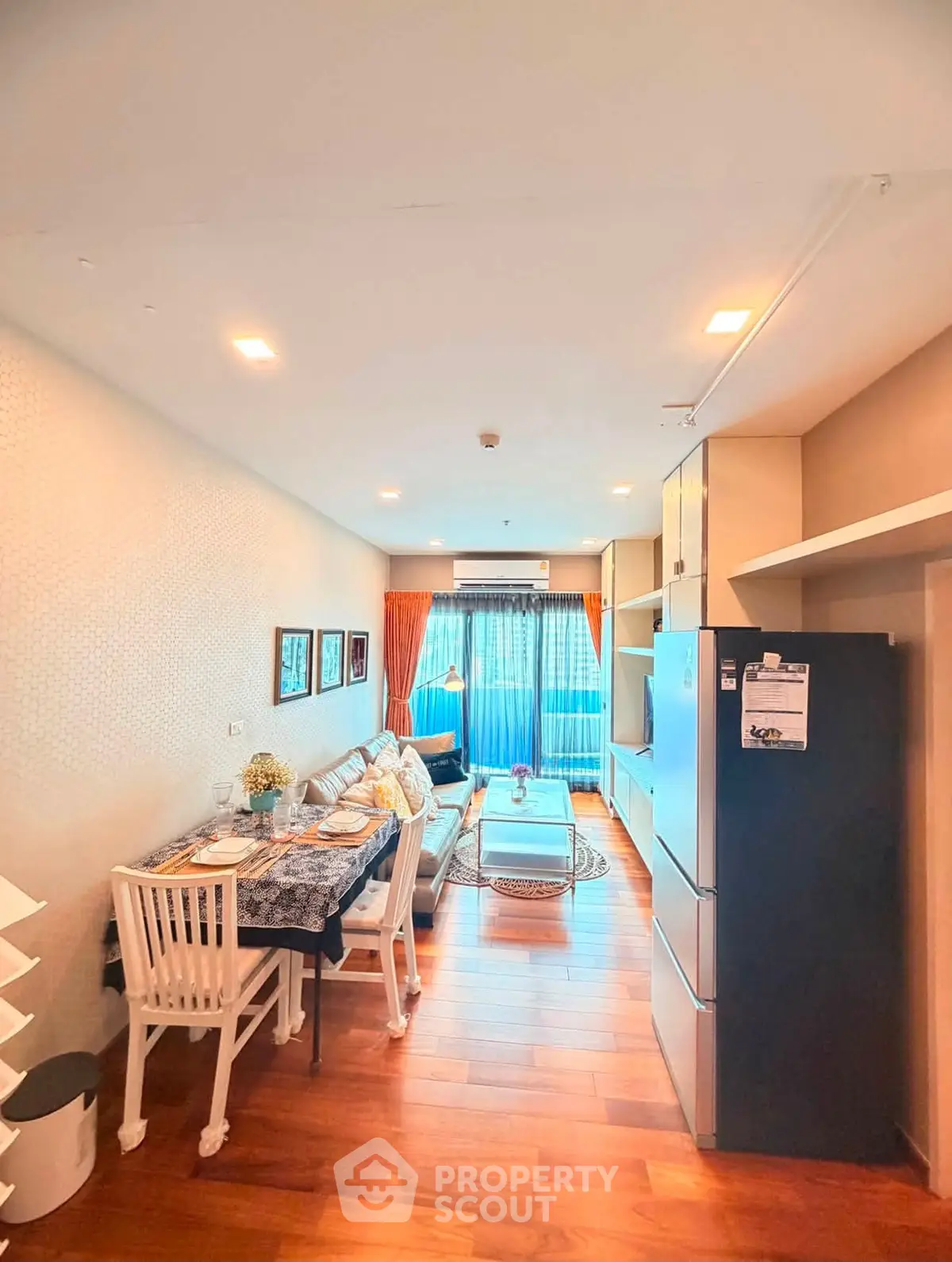 Modern living room with dining area and large windows in a stylish apartment.