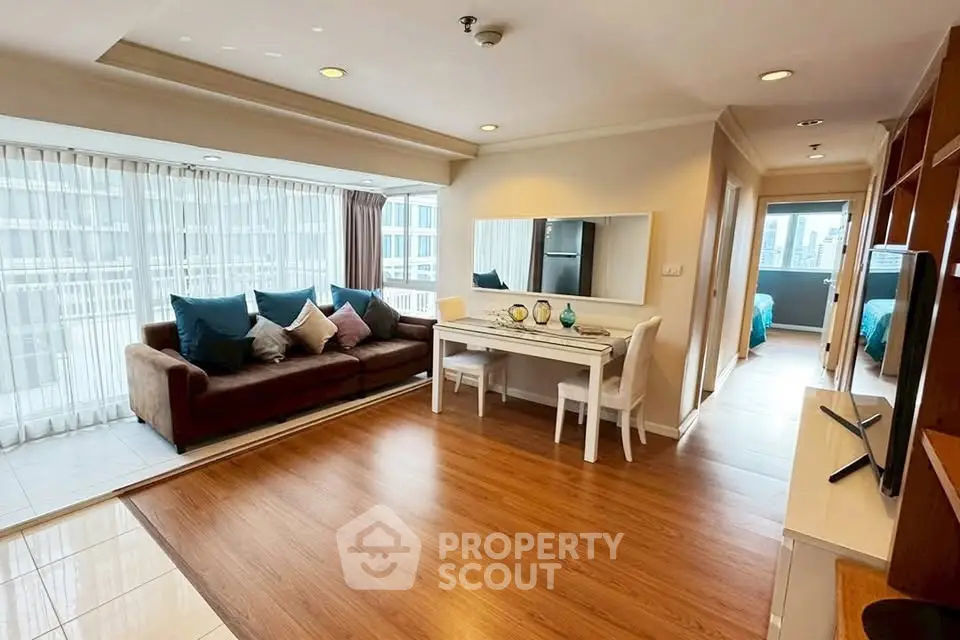 Spacious living room with elegant decor and large windows offering city views